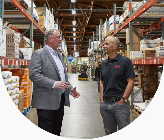 banker talks to business person in warehouse