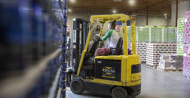 Person operates forklift in warehouse