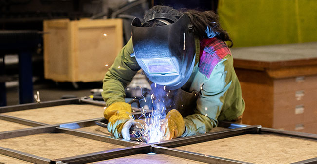 Worker welding in a factory