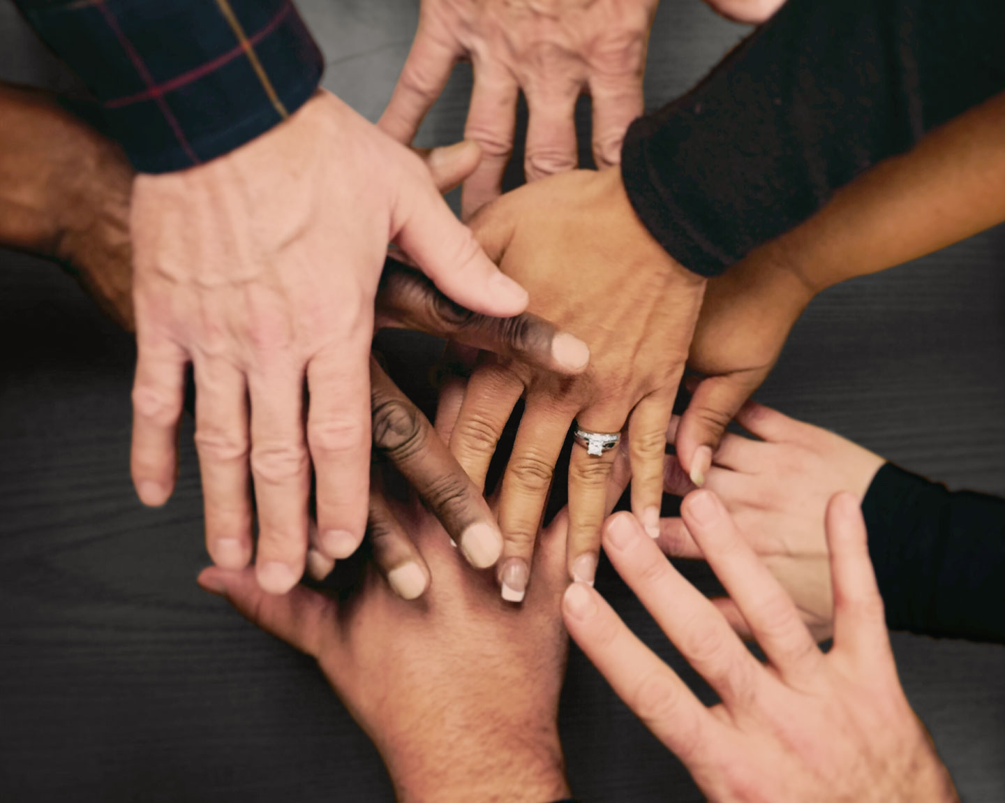 Group of hands come together representing people from diverse backgrounds